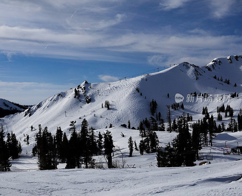 山峰和山峰映衬着模糊的冬日天空。Palisades Tahoe滑雪胜地，加利福尼亚。